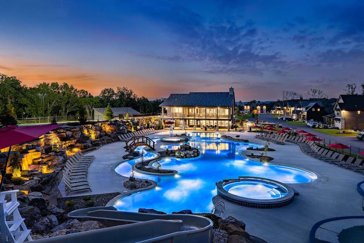 Serenity Shores main pool, waterslide and resort lodge at twilight